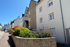 a stone retaining wall in front of a building at Appartement centre ville avec parking proche grande plage in Quiberon