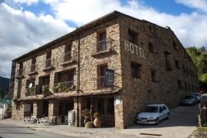 un edificio de piedra con un coche aparcado delante de él en Hotel Rural Los Angeles en Las Hurdes, en Vegas de Coria