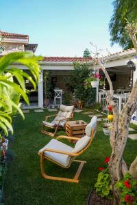 a yard with two lounge chairs and a table at Müzeyyen Hanım Konağı Alaçatı in Alacati