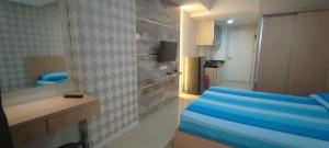 a small room with a bed and a bathroom at Vast! Metro Park Manhattan 2BR & Studio in Jakarta +69 photos
