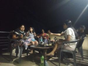 a group of people sitting around a table in the dark at Jitendra home stay in Sari