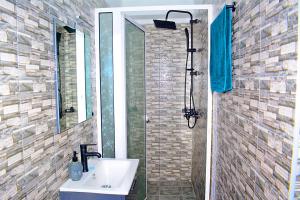 een badkamer met een wastafel en een douche bij Appart city in Tokpokondji +8 foto's