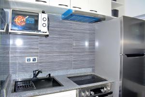 een keuken met een spoelbak en een magnetron bij Appart city in Tokpokondji