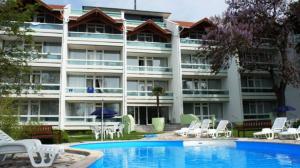 a hotel with a swimming pool in front of a building at Füred Central Apartman in Balatonfüred +5 photos