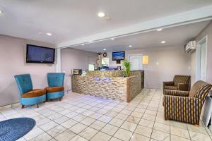 a waiting room with blue chairs and a counter at Travelodge by Wyndham Austin South in Austin