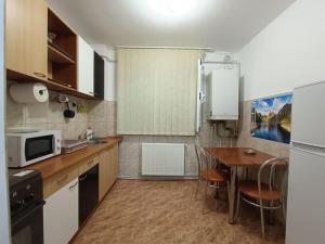 a small kitchen with a table and a microwave at Apartament Alis2011 in Buzău