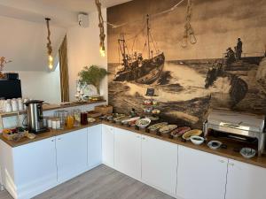 a kitchen with a mural of a ship on the wall at Apartament DALBA in Krynica Morska