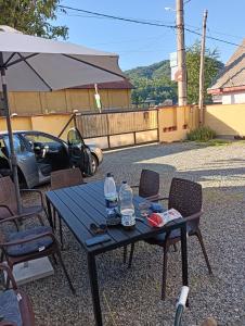 a picnic table and chairs with water bottles on it at Casa Cerbului in Vişeu de Sus