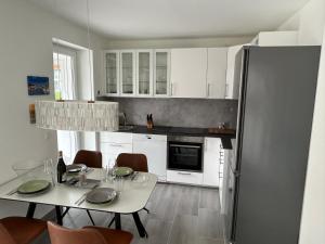 a kitchen with white cabinets and a white table and chairs at Timmendorfer Herz in Timmendorfer Strand