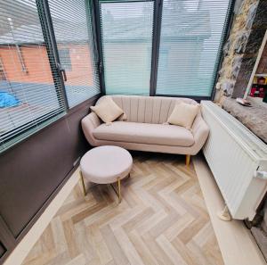 a living room with a couch and a stool at Le sapin bleu in Hastière-par-delà