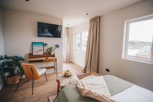 a bedroom with a bed and a desk and a window at Hotel Boutique Lamar de Suances in Suances