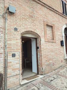 an open door in a brick building with a table at Appartamento di Porta Maggiore in Cupra Marittima
