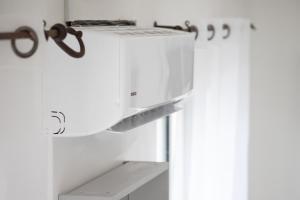 a microwave oven sitting on top of a refrigerator at Le Partage des eaux - 4 couchages - Hypercentre - Clim - Wifi in LʼIsle-sur-la-Sorgue