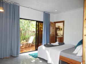 una camera da letto con un letto e una porta scorrevole in vetro di CosyBe Villas a Praia do Tofo
