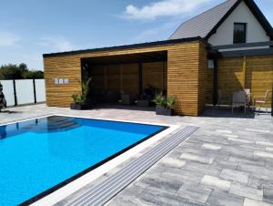 a swimming pool in front of a house at Osada Jackowo in Jarosławiec