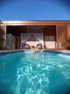 a large swimming pool with blue water at Casa com piscina aquecida em Itapoá in Itapoa