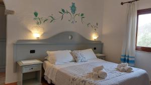 una camera da letto con un letto su cui sono appoggiati due asciugamani di Hotel Cardedu a Cardedu
