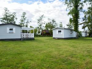 zwei Mobilheime in einem grasbewachsenen Hof mit Bäumen in der Unterkunft Delta Mare - Ferienhaus Folklore - 250m zum Strand in Dziwnów