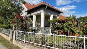a white fence in front of a house at Greenapple Apartman Badacsony in Badacsonytördemic
