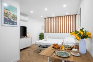Una habitación con una cama y una mesa con comida encima. en La perle, en Menton