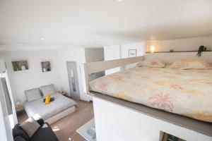 a white bedroom with a bed and a couch at Le Partage des eaux - 4 couchages - Hypercentre - Clim - Wifi in LʼIsle-sur-la-Sorgue