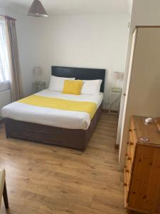 a bedroom with a large bed with a yellow blanket at Doonhill Lodge in Galway +3 photos