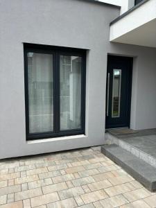 a house with black windows and a sidewalk at Studio Bleu in Obernai