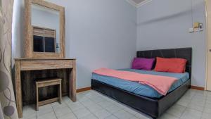 a bedroom with a bed with a mirror and a fireplace at Bunut Centre Stay in Bandar Seri Begawan