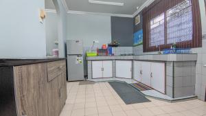a kitchen with white cabinets and a refrigerator at Bunut Centre Stay in Bandar Seri Begawan +5 photos