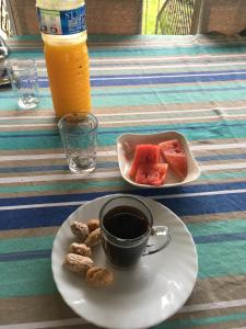 a plate with a cup of coffee and a plate of fruit at Farida Lodge in Moroni