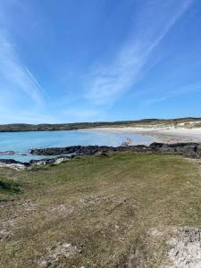 a beach with a body of water and some grass at Doonhill Lodge in Galway