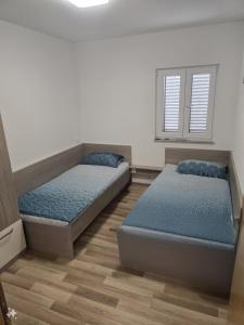 a bedroom with two beds and a window at Spacious 3 Bedroom Apartment 50m from Sea 2 Bathrooms 2 Terraces Near Beach in Privlaka