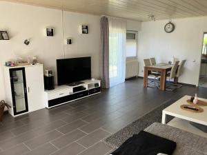 a living room with a television and a table at Gemütlicher Bungalow in Barum