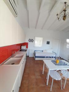 a kitchen with a sink and a table and a bed at Vasiliki in Kavála +20 photos