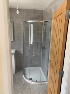 eine Dusche mit Glastür im Badezimmer in der Unterkunft Mourne Country Cottage in Warrenpoint + 9 Fotos