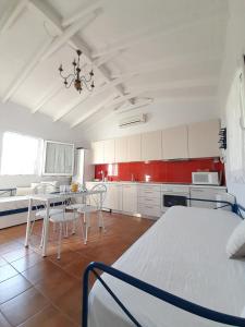 a room with a bed and a table and a kitchen at Vasiliki in Kavála