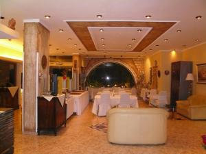 a banquet hall with white tables and white chairs at Galini Palace in Athens