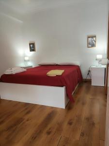 a bedroom with a large bed with a red blanket at Casa da Avo Maria - 2 in Podence