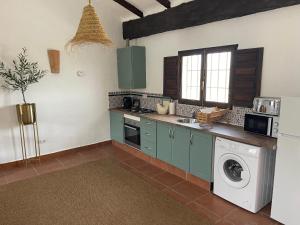a kitchen with a washing machine and a washer at MiLuna Oasis Suites in Huércal-Overa
