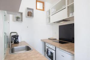 a kitchen with a sink and a counter top at Le Partage des eaux - 4 couchages - Hypercentre - Clim - Wifi in LʼIsle-sur-la-Sorgue +16 photos