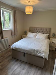 a bedroom with a large bed with white sheets and pillows at The Jockey's Lodge @ Danebury in Stockbridge
