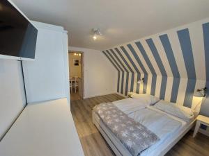 a bedroom with a bed with a striped wall at Bajkowy Las in Pobierowo