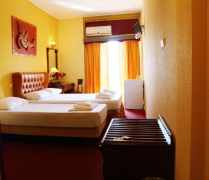 a hotel room with two beds and a window at Galini Palace in Athens