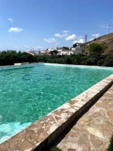 una piscina con acqua turchese di Cortijo Torreblanca Casa Rural Parque Natural Cabo de Gata a El Pozo de los Frailes