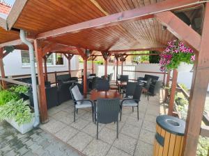a patio with tables and chairs under a wooden pergola at Hotel Orlan in Bratislava