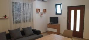 Televízia a/alebo spoločenská miestnosť v ubytovaní Apartmani Ivan & Mirjana 2