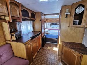 a small kitchen with wooden cabinets in an rv at CampOloHel- przyczepa kempingowa in Hel
