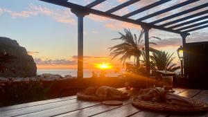 a table with food on it with the sunset in the background at Casa Moni con Vistas al Mar in Playa de Santiago