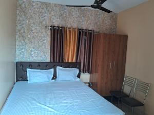 ドゥルガポにあるWB40 Guest Houseのベッドルーム(青いベッド1台、椅子付) +5枚の写真