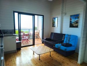 a living room with a blue couch and a table at Kaz Samèm in Les Avirons